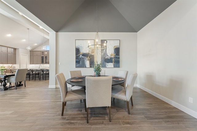 dining space with dark hardwood / wood-style floors, a chandelier, and vaulted ceiling