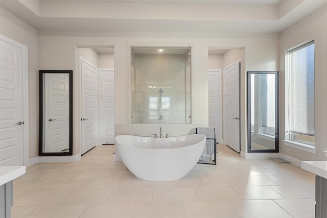 bathroom with tile patterned flooring, separate shower and tub, and a wealth of natural light