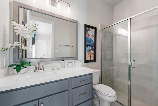 bathroom featuring toilet, an enclosed shower, and vanity