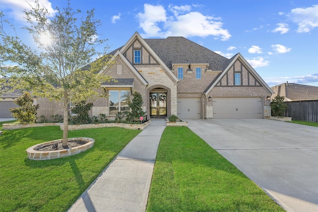 view of front of house with a garage, french doors, and a front lawn