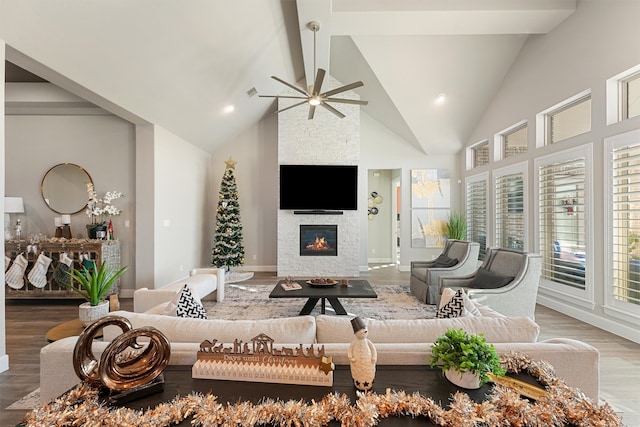 living room with a fireplace, hardwood / wood-style floors, high vaulted ceiling, and ceiling fan