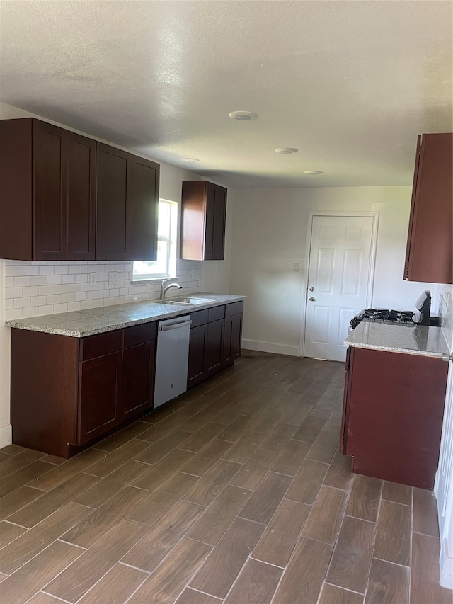 kitchen with a textured ceiling, dark brown cabinetry, sink, dishwasher, and white stove