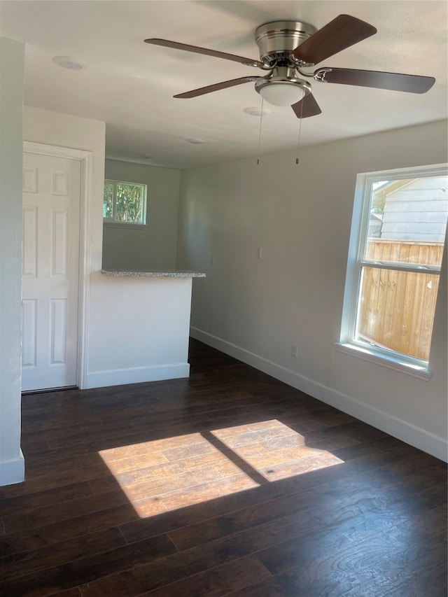 empty room with ceiling fan and dark hardwood / wood-style flooring