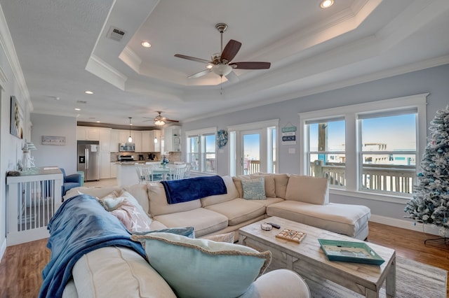 living room with plenty of natural light, ornamental molding, and light hardwood / wood-style flooring