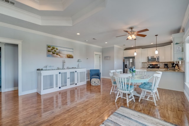 dining space featuring ceiling fan, crown molding, and light hardwood / wood-style flooring