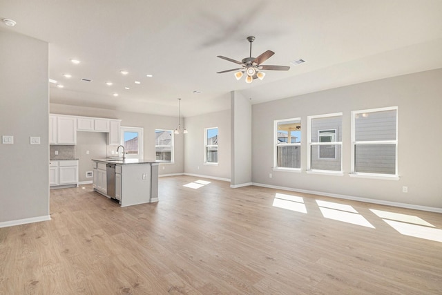 unfurnished living room featuring sink, light hardwood / wood-style floors, and ceiling fan