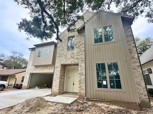 view of front of home featuring board and batten siding, a garage, and concrete driveway