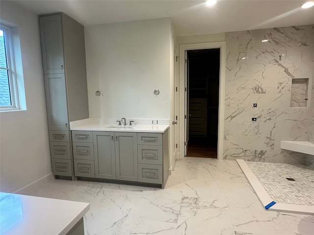 bathroom with vanity, marble finish floor, a marble finish shower, and a spacious closet