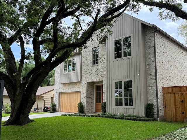 view of front of home featuring board and batten siding, driveway, a front lawn, and a garage