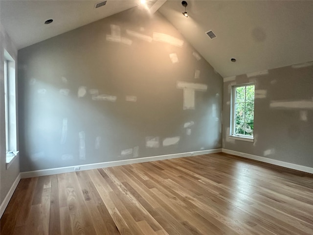 interior space with visible vents, baseboards, lofted ceiling, and wood finished floors
