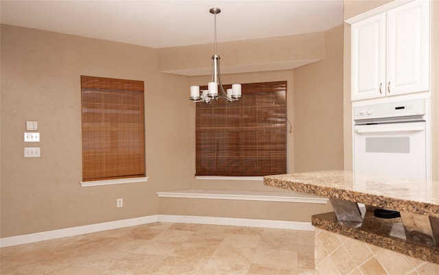 unfurnished dining area featuring a chandelier