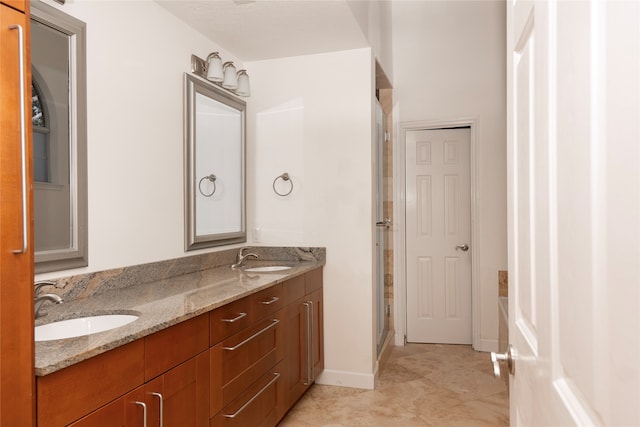 bathroom with tile patterned flooring, vanity, and walk in shower