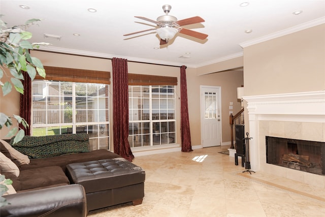 living room with ceiling fan, a fireplace, and ornamental molding