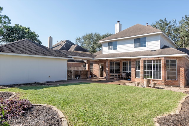 rear view of house with a patio area and a lawn