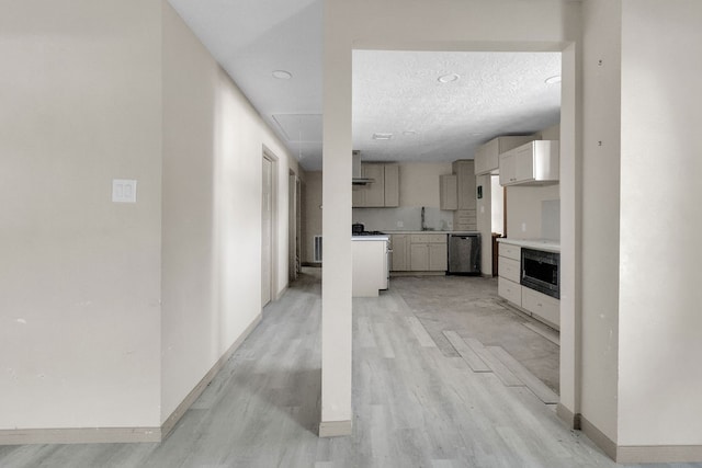 corridor with sink, a textured ceiling, and light hardwood / wood-style flooring