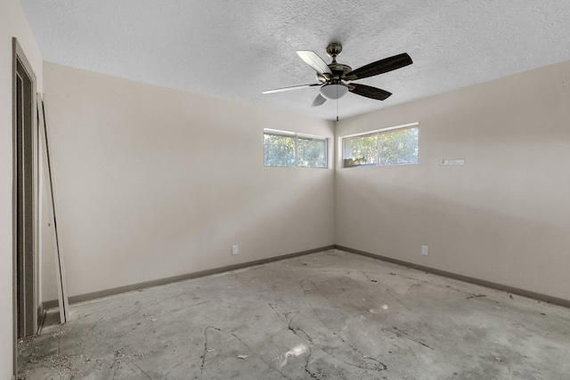 empty room with a textured ceiling and ceiling fan