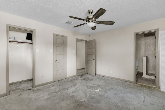 unfurnished bedroom featuring ceiling fan, a textured ceiling, and multiple closets