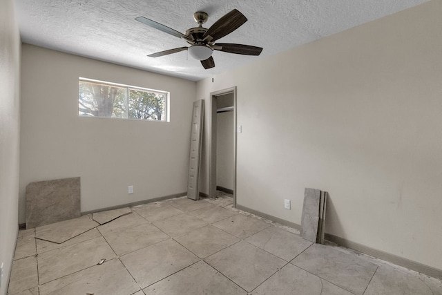 tiled spare room with a textured ceiling and ceiling fan