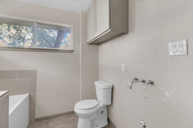 bathroom with toilet, a bathtub, and tile patterned flooring