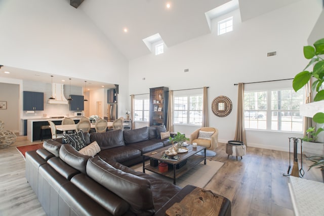 living room with light wood-type flooring and high vaulted ceiling