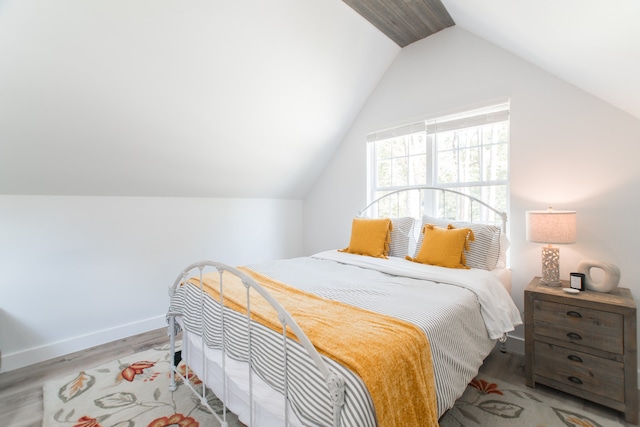 bedroom featuring light hardwood / wood-style flooring and vaulted ceiling