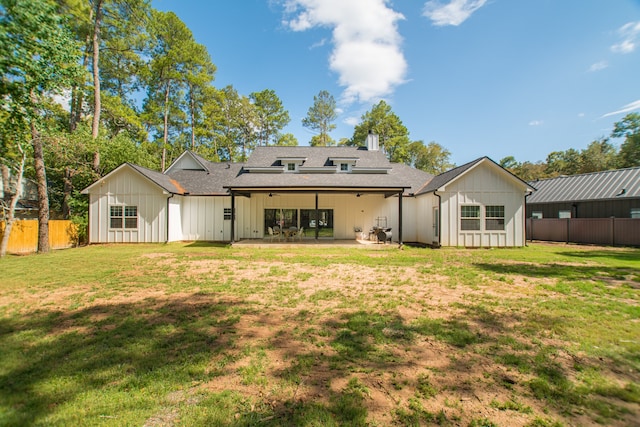 rear view of property with a yard and a patio