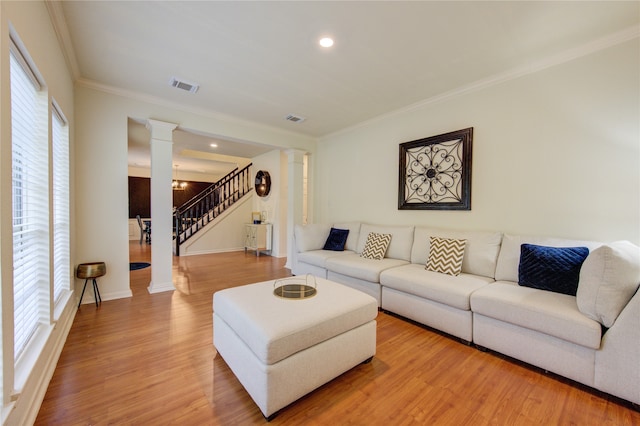 living room with wood-type flooring, crown molding, and a wealth of natural light