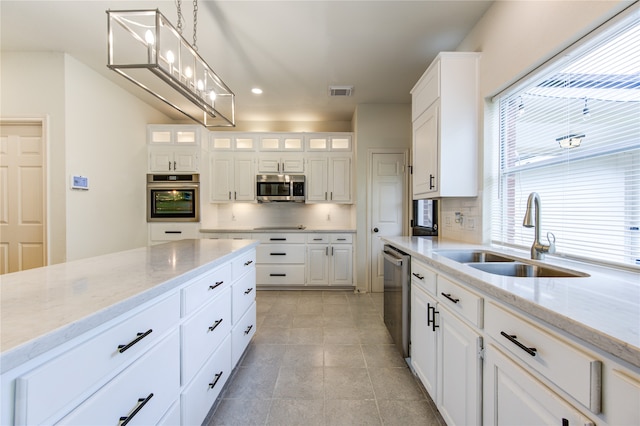 kitchen featuring white cabinets, hanging light fixtures, sink, and appliances with stainless steel finishes