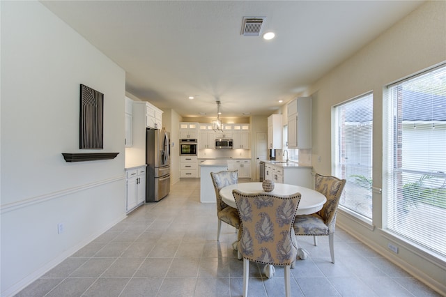 tiled dining room featuring a healthy amount of sunlight