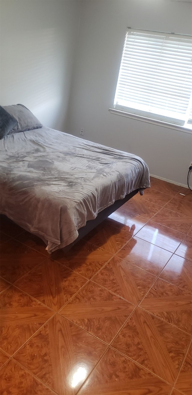 bedroom with multiple windows and tile patterned flooring