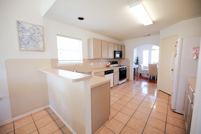 kitchen with kitchen peninsula, white appliances, sink, and a wealth of natural light