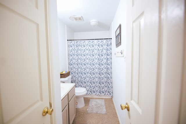 bathroom featuring curtained shower, tile patterned flooring, vanity, and toilet