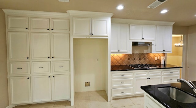 kitchen with sink, light tile patterned floors, tasteful backsplash, white cabinetry, and stainless steel gas cooktop