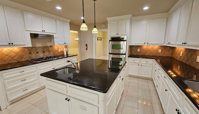 kitchen featuring pendant lighting, stainless steel appliances, white cabinetry, and sink