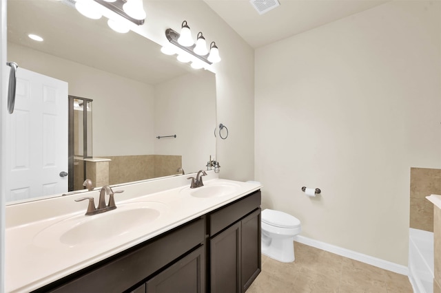 bathroom with tile patterned flooring, vanity, toilet, and a tub