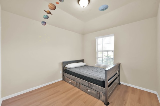 bedroom with light hardwood / wood-style floors and vaulted ceiling