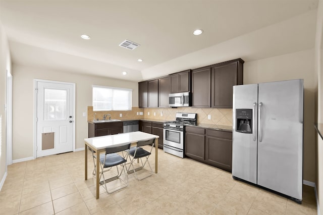 kitchen with sink, tasteful backsplash, dark brown cabinets, light tile patterned flooring, and stainless steel appliances