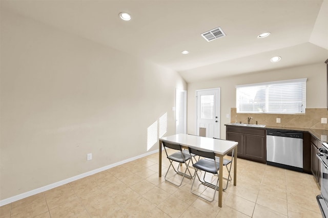 kitchen with dark brown cabinetry, sink, lofted ceiling, light tile patterned floors, and appliances with stainless steel finishes