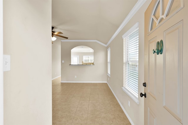 entrance foyer with ornamental molding, ceiling fan, a healthy amount of sunlight, and light tile patterned flooring