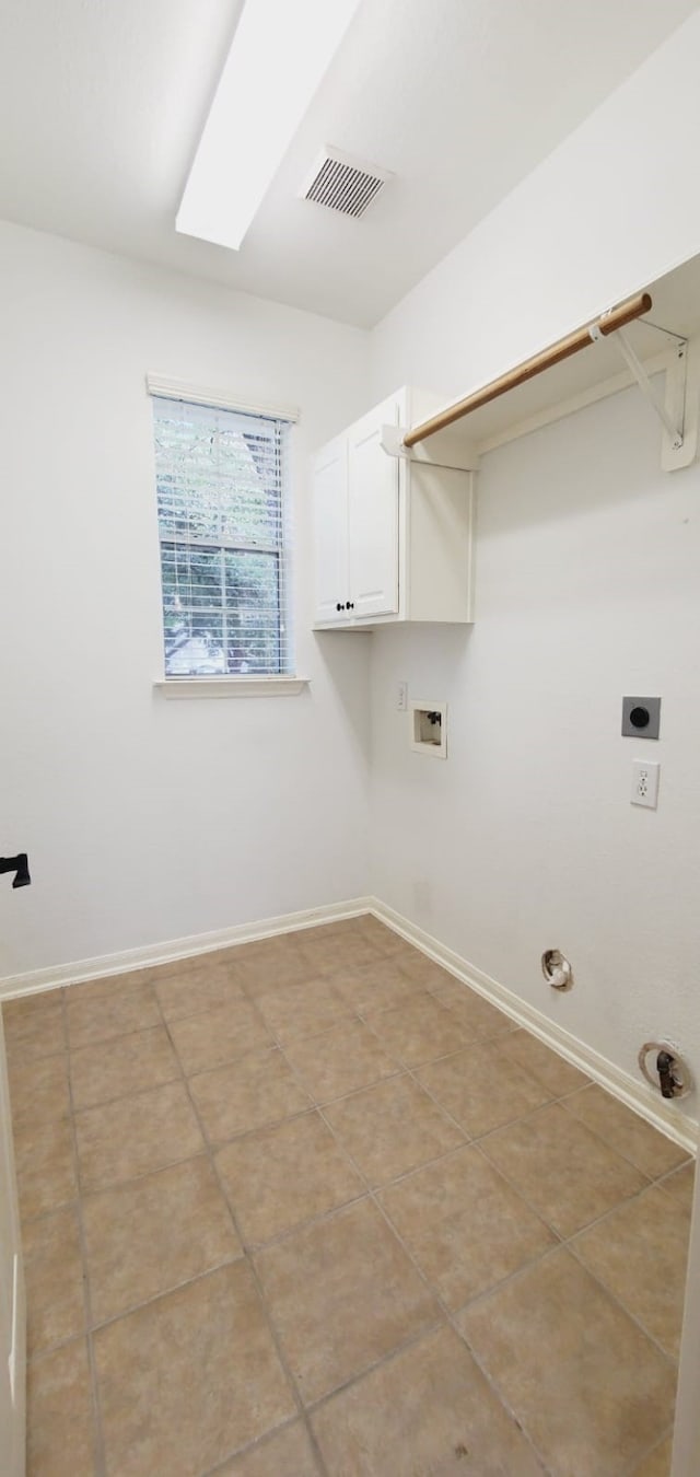 washroom featuring cabinets, hookup for an electric dryer, gas dryer hookup, hookup for a washing machine, and light tile patterned floors