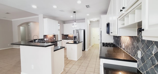 kitchen with backsplash, black appliances, kitchen peninsula, decorative light fixtures, and white cabinetry