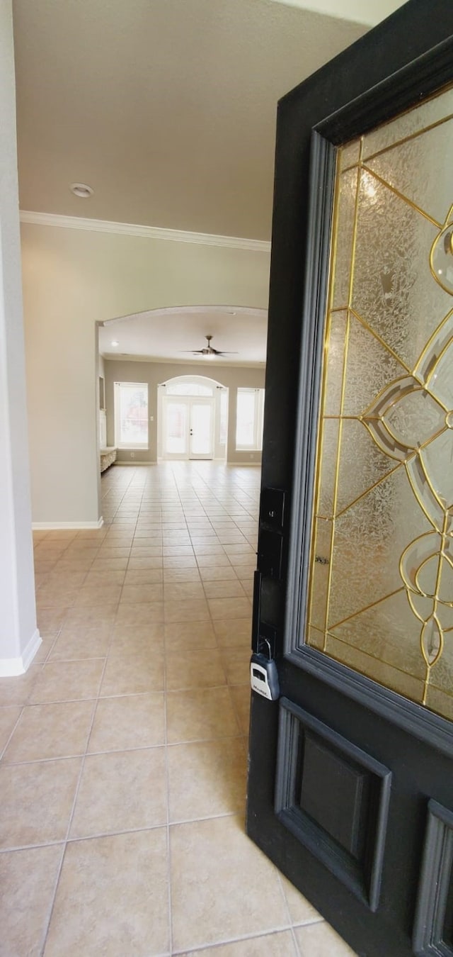 hallway featuring tile patterned flooring and ornamental molding