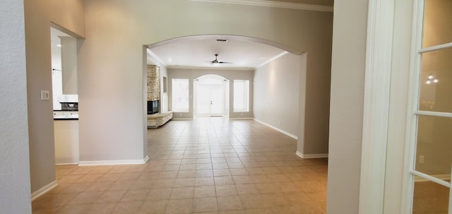 corridor with light tile patterned flooring and crown molding