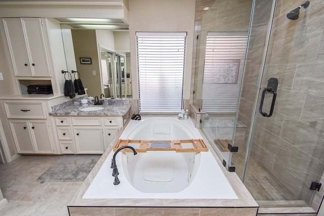 bathroom with shower with separate bathtub, vanity, and tile patterned floors