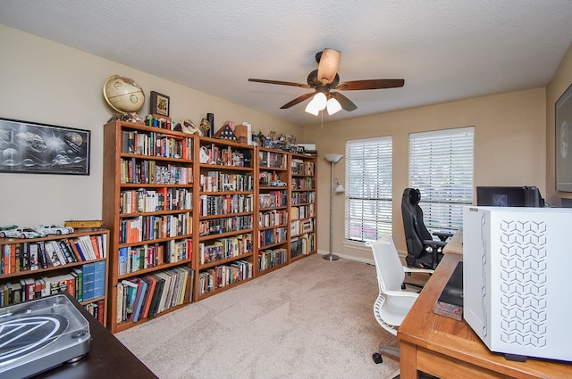 carpeted office featuring ceiling fan and a textured ceiling