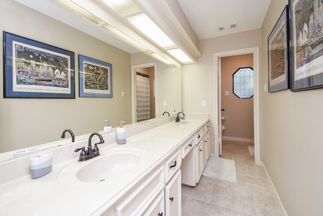 bathroom with tile patterned flooring, vanity, and toilet