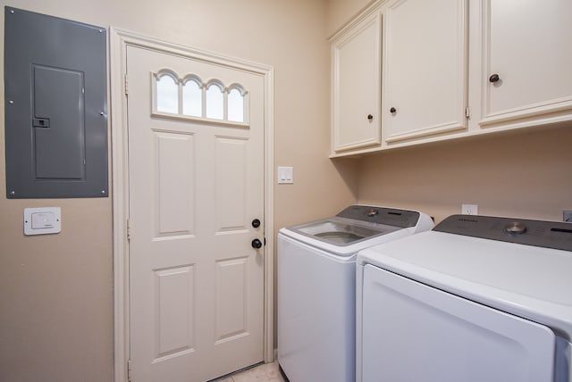 clothes washing area with cabinets, electric panel, and washer and clothes dryer