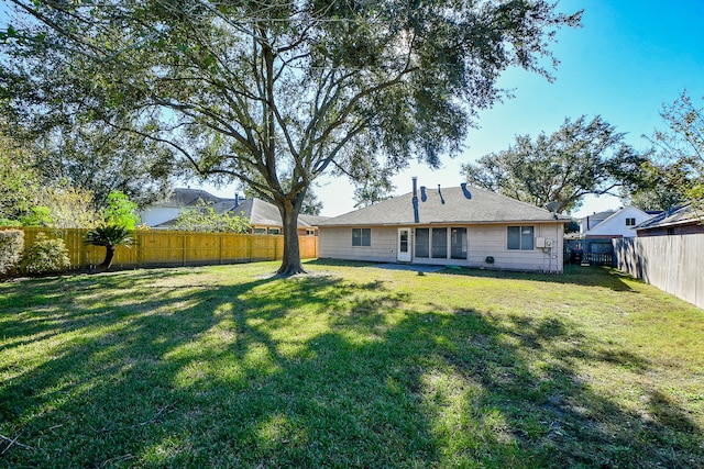 rear view of property featuring a lawn