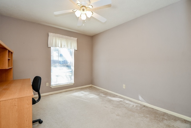 unfurnished office featuring light carpet and ceiling fan