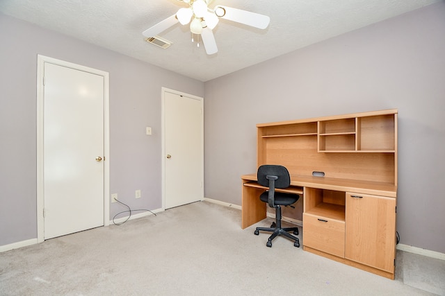 carpeted office featuring ceiling fan and a textured ceiling